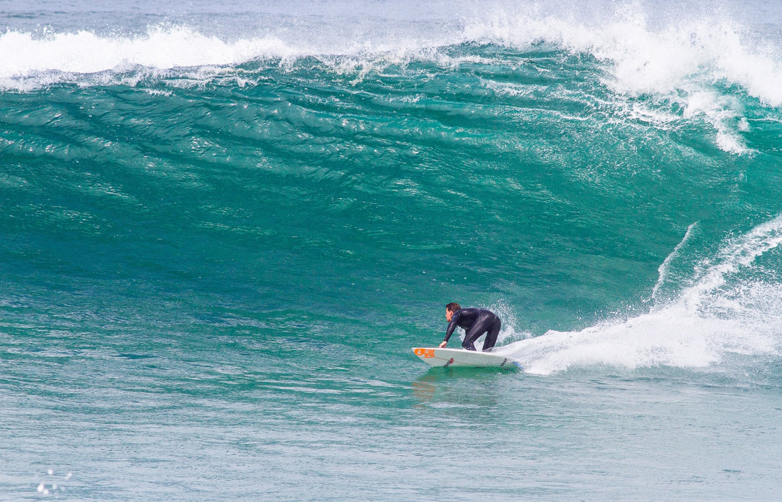 Surfer making a bottom turn on a large turquoise wave